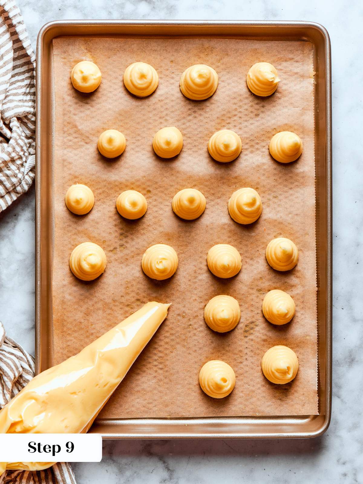 piped choux pastry rounds on brown parchment.