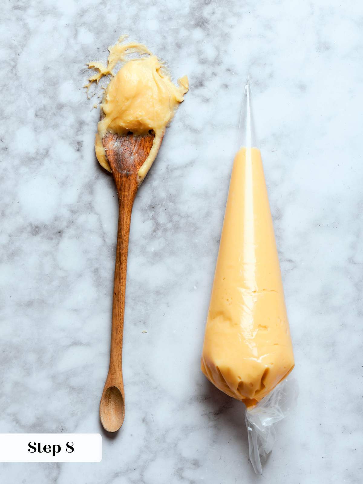 choux paste in piping bag and on spoon on marble.