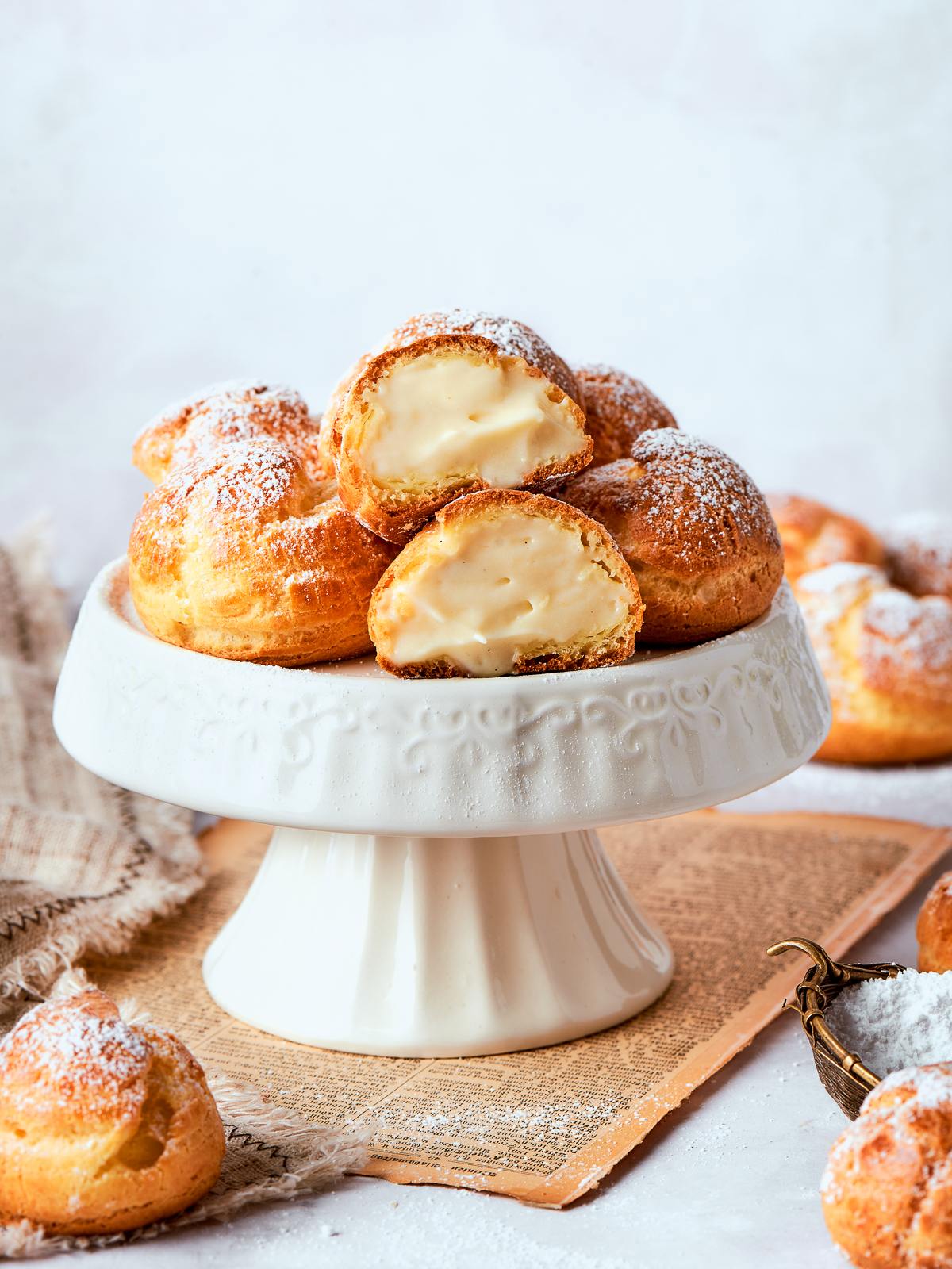 Light vanilla pastry cream inside cream puffs showing thick yet airy consistency.