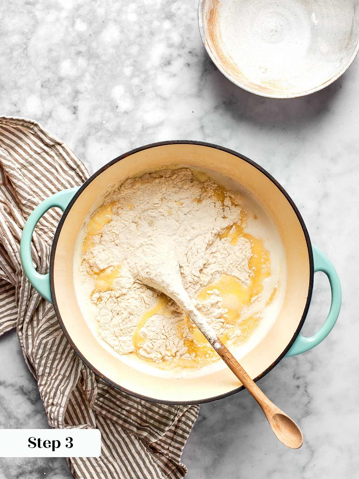 Flour mixture added to hot liquid forming initial choux paste in saucepan.