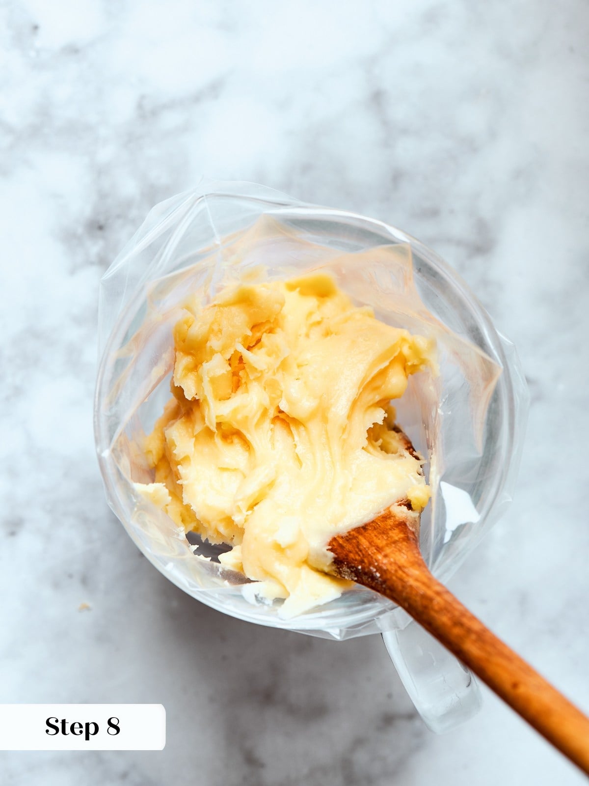 Thick choux paste loaded into piping bag ready to form uniform gougère rounds.