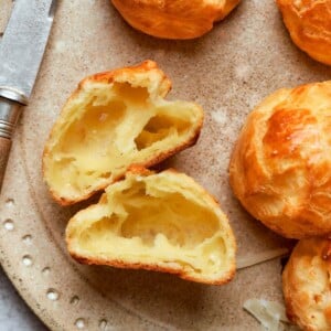 Interior of gougère showing large hollow pocket and delicate airy crumb structure.