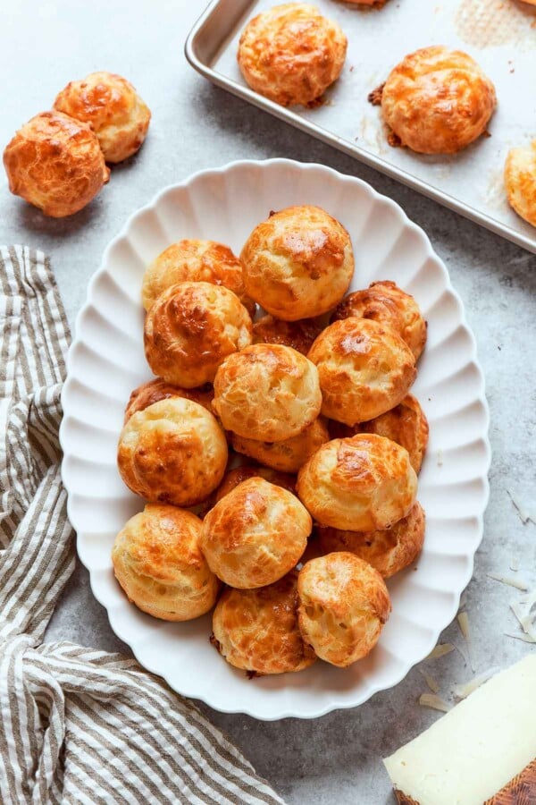 Gougรจres arranged on white plate highlighting golden color and uniform puffed shape.
