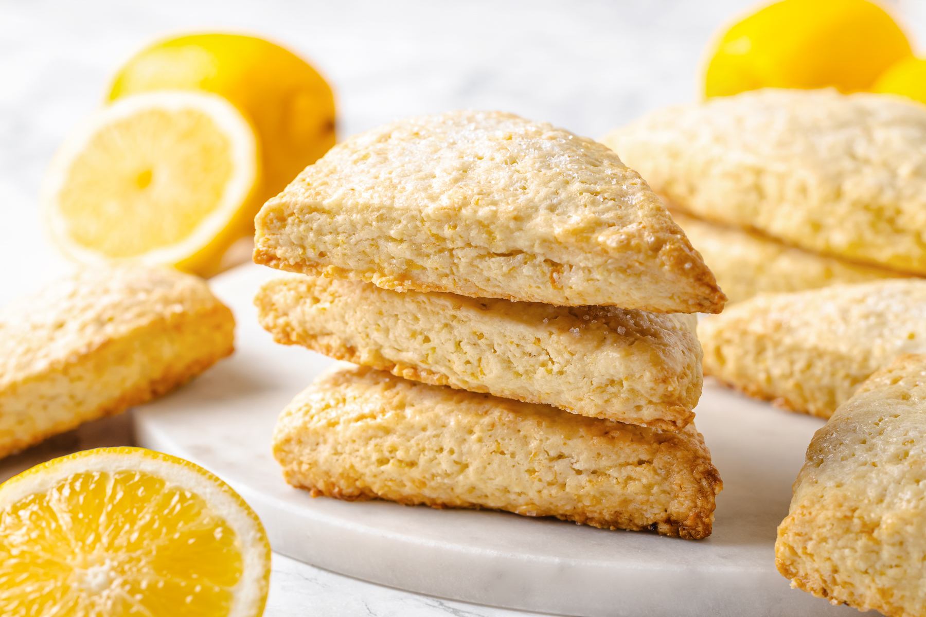 Fresh lemons alongside baked lemon scones highlighting citrus ingredients used for bright flavor.