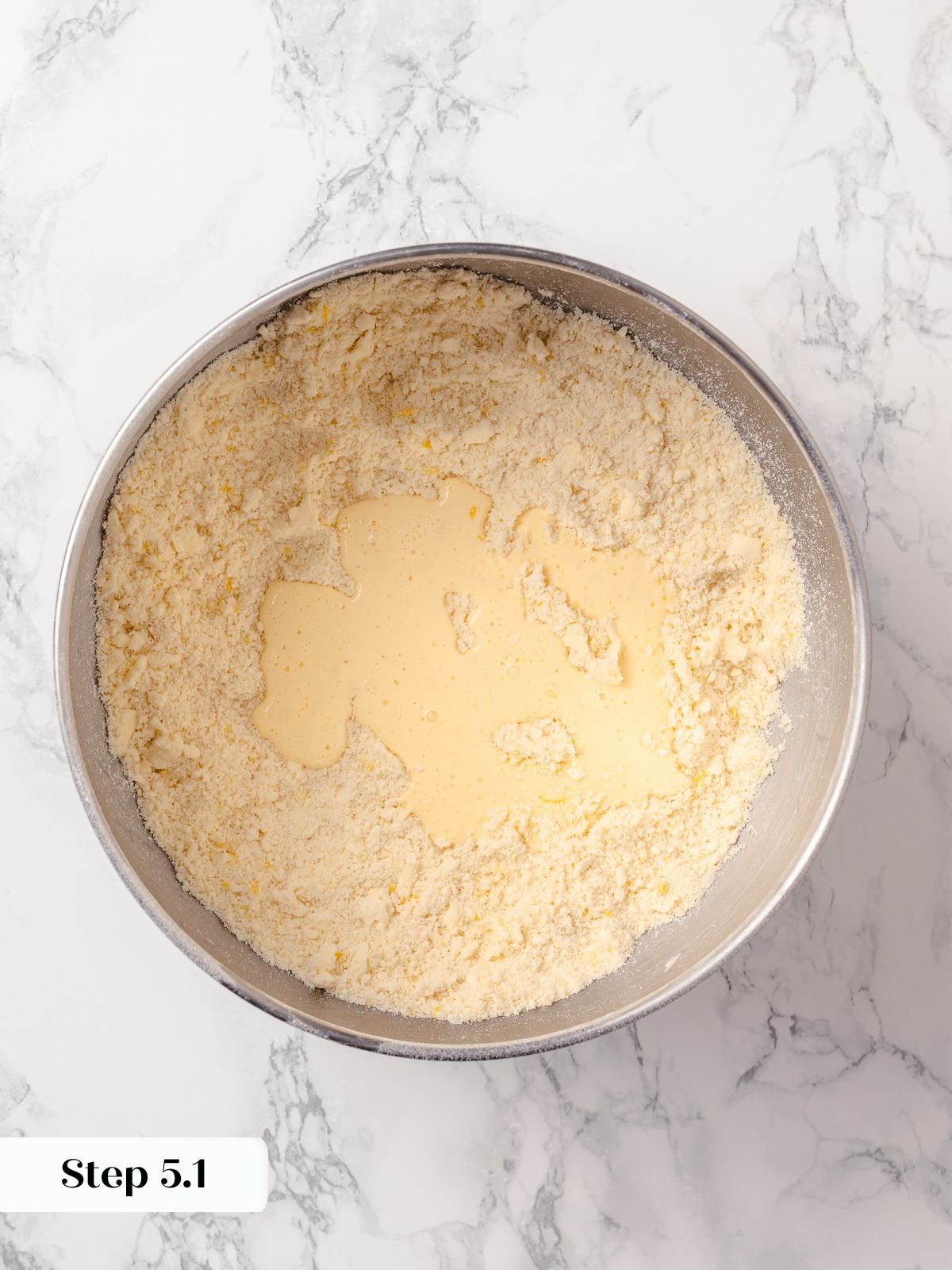 Wet ingredients gently mixed into dry ingredients forming soft scone dough without overworking.