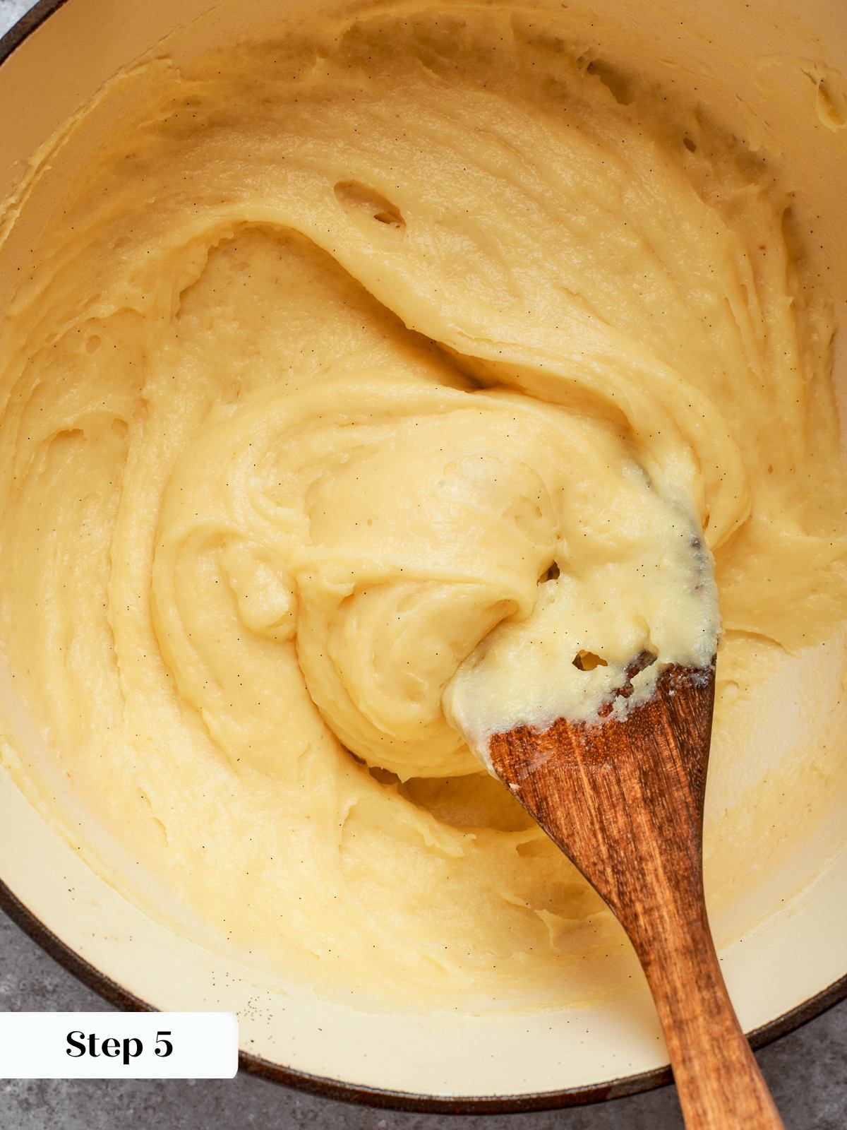 Thickened pastry cream in pot after cooking, smooth and glossy from constant whisking.