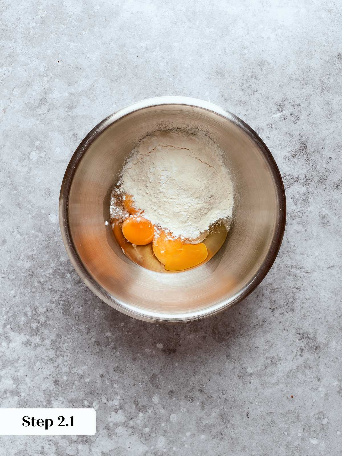 Eggs and sugar being whisked together in a bowl to form the pastry cream base.