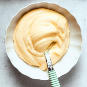 Pastry cream scooped onto a spoon, demonstrating its dense, silky consistency and structure.