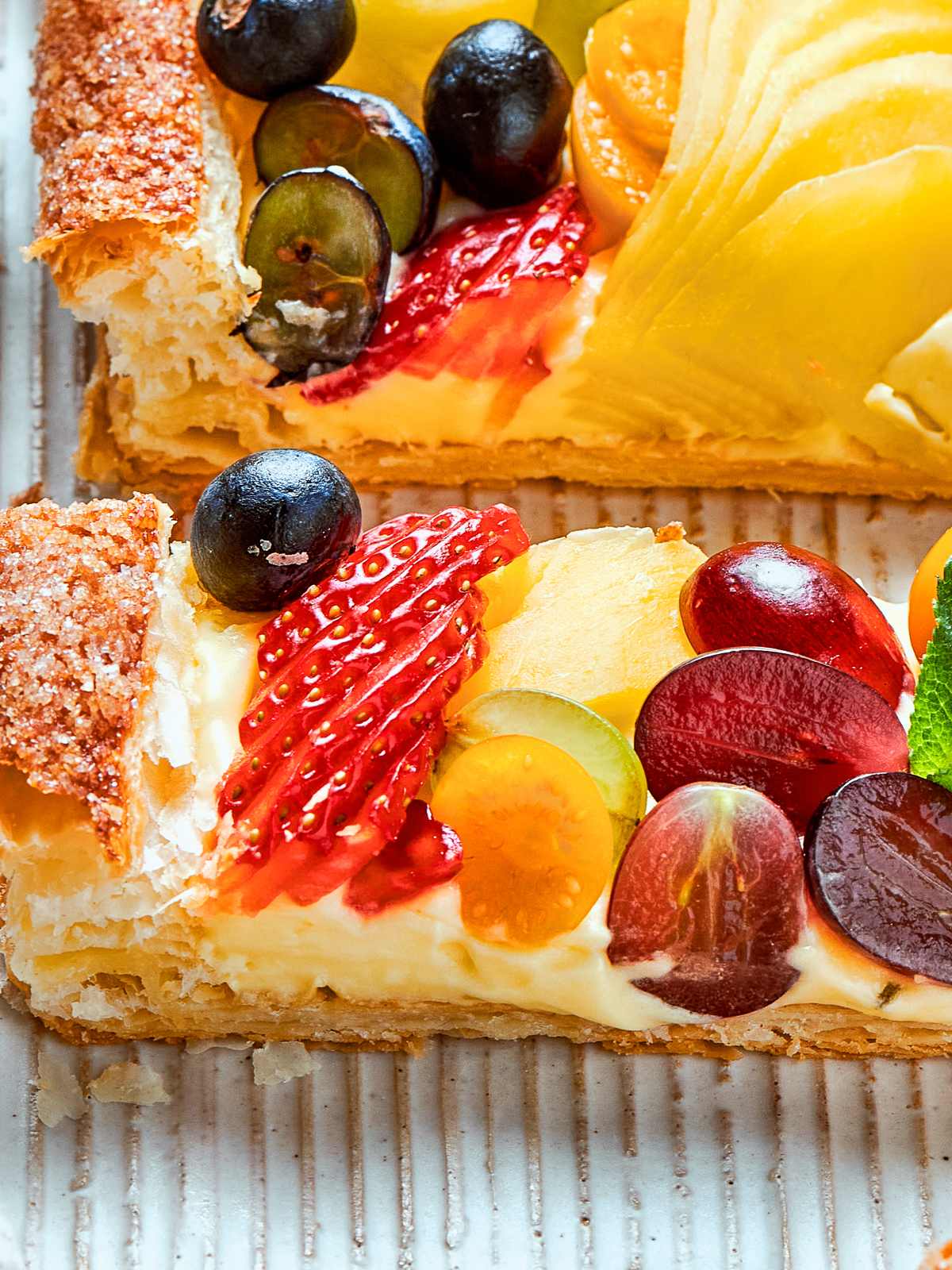 Thick pastry cream spread under sliced fruit, forming a rich filling for tarts.