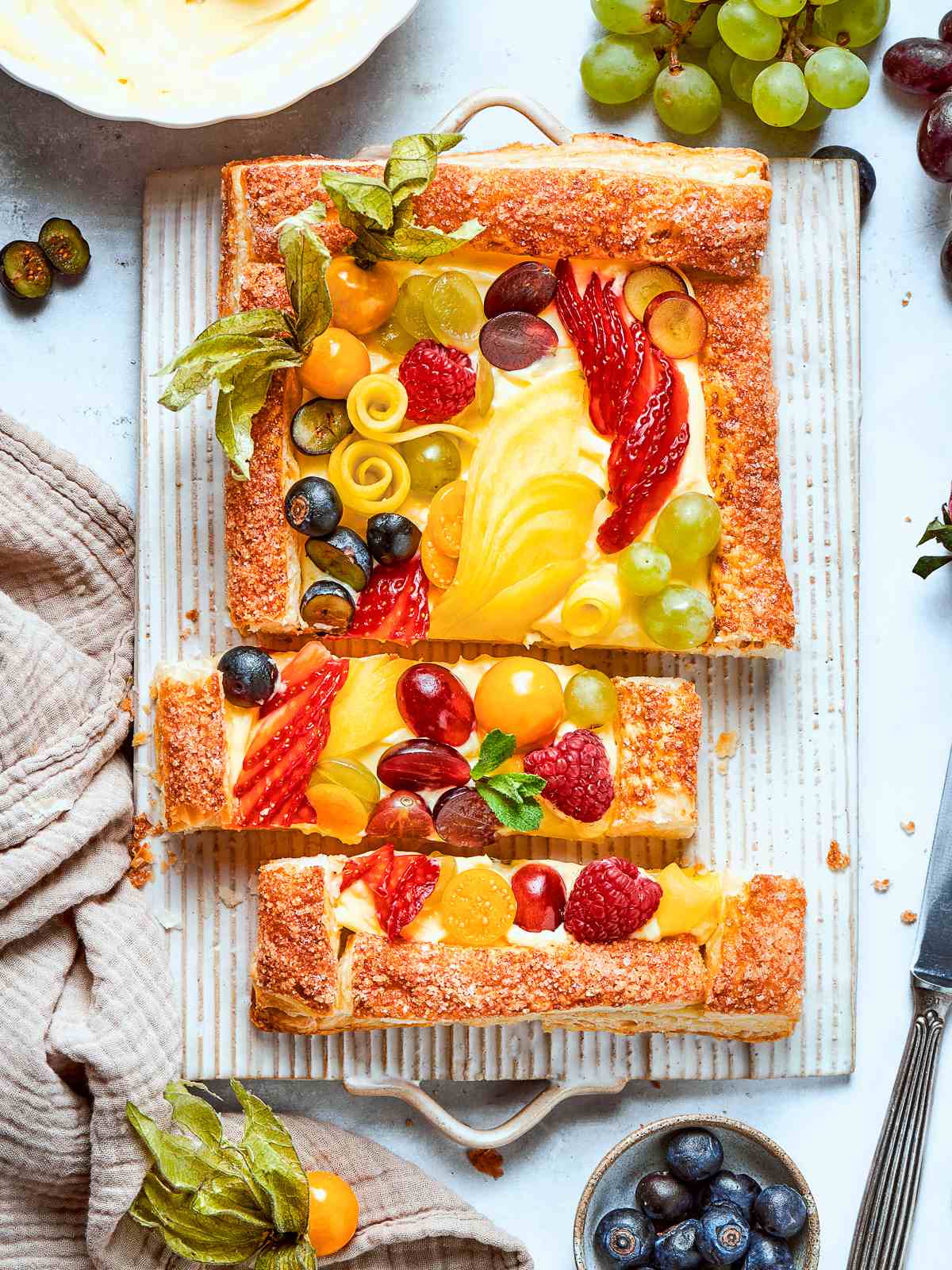Tart topped generously with fresh berries including strawberries, raspberries, and blueberries.