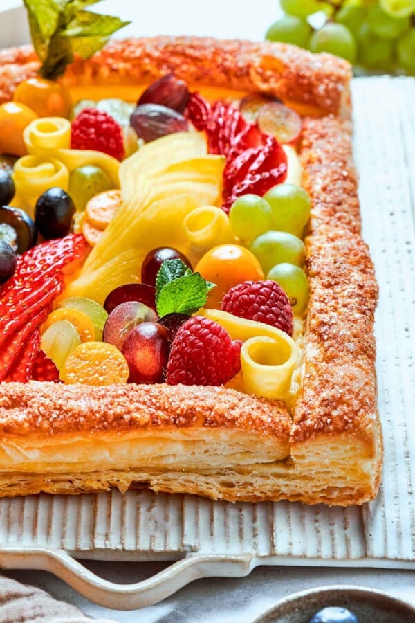 Brightly colored fruit tart presented against white background for clean, simple contrast.