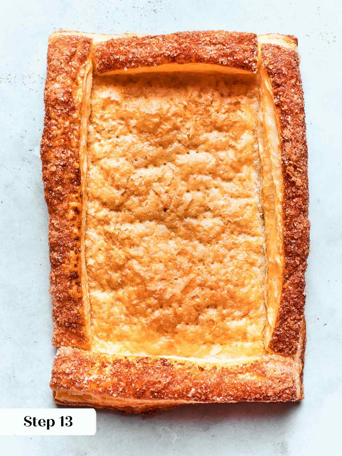 Golden puff pastry tart shell with raised edges and crisp, flaky layers after baking.
