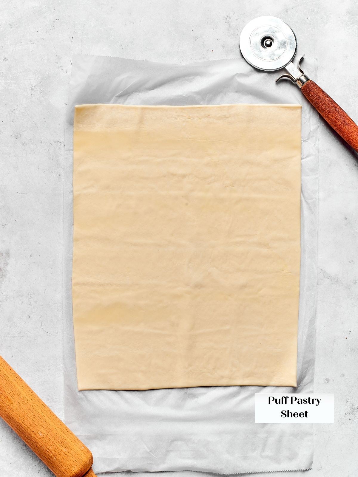 Sheet of puff pastry resting on countertop, slightly thawed and ready to shape.