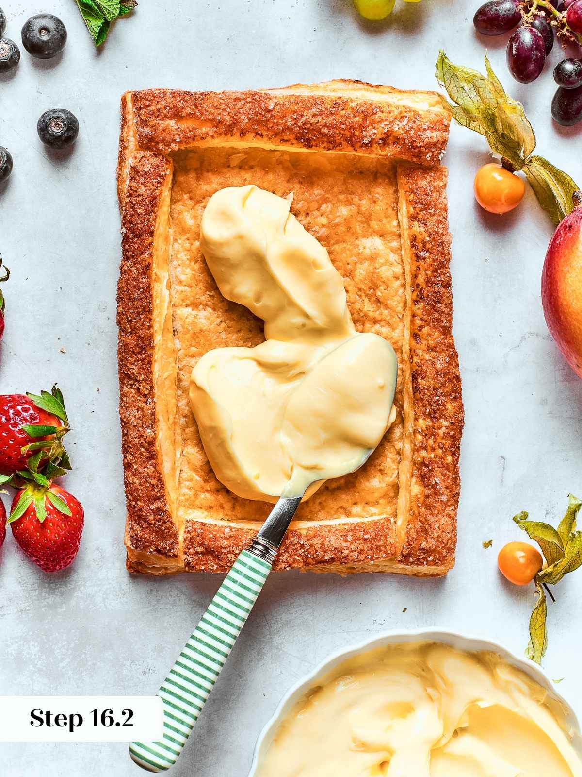 Filling tart shell with pastry cream, smoothing gently to level surface.