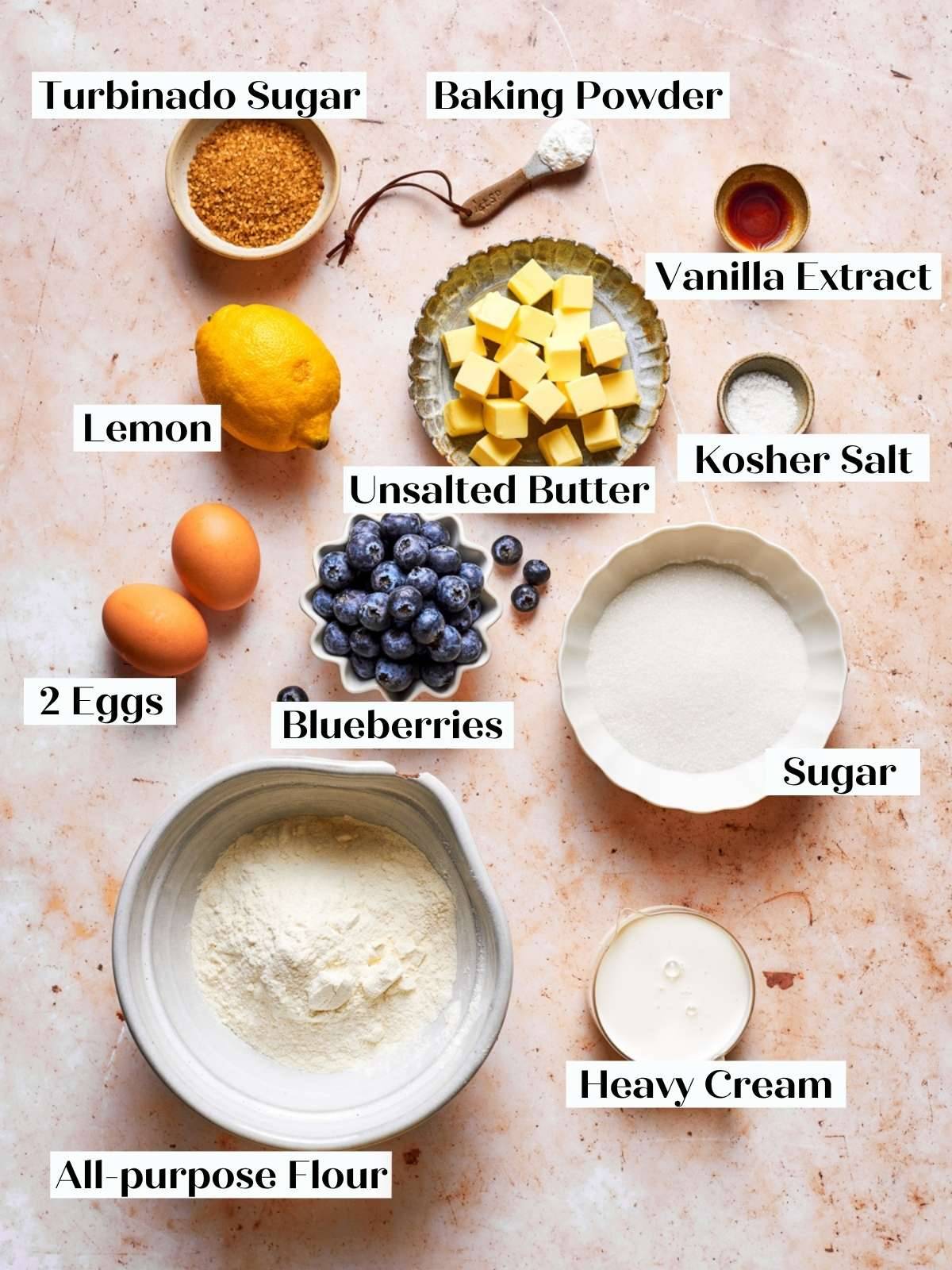 Fresh blueberries, lemon, butter cubes, and pantry staples gathered for making blueberry scones from scratch.