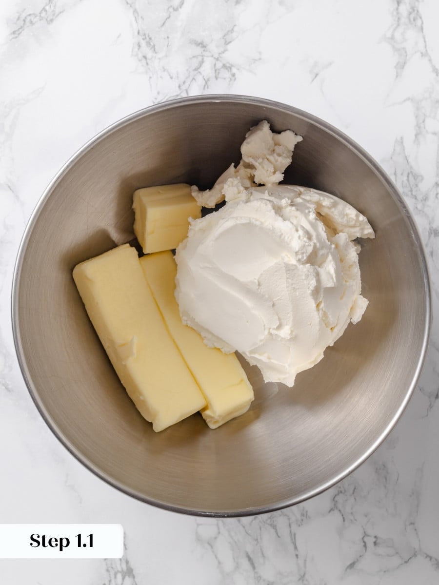 Sticks of butter and block cream cheese in a stainless steel mixing bowl before beating.