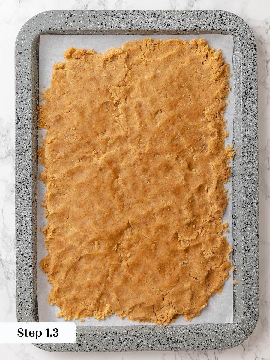 Spreading it thin on parchment helps the crumb cake topping firm up quickly before baking.