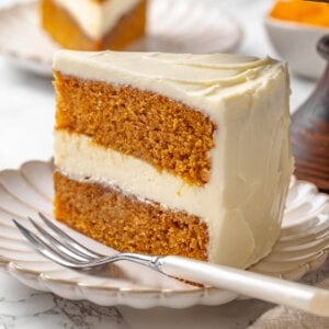 Another angle on the sliced pumpkin cake highlights the even layers and smooth cream cheese frosting.