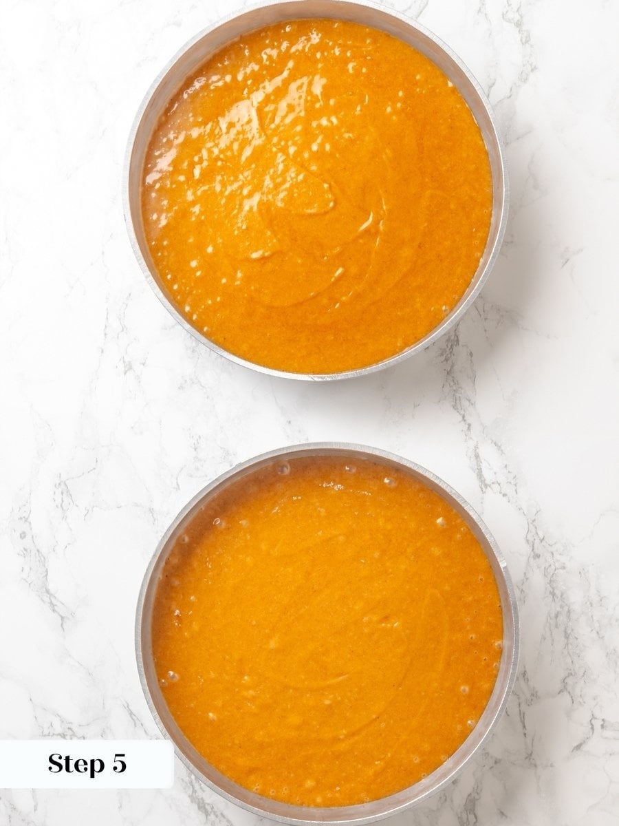 Dividing the batter evenly helps both pumpkin cake layers bake flat and finish at once.