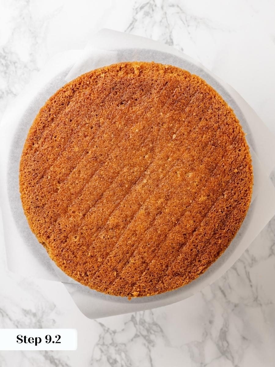 Stacking the second layer squarely sets up clean, even sides on the assembled pumpkin cake.