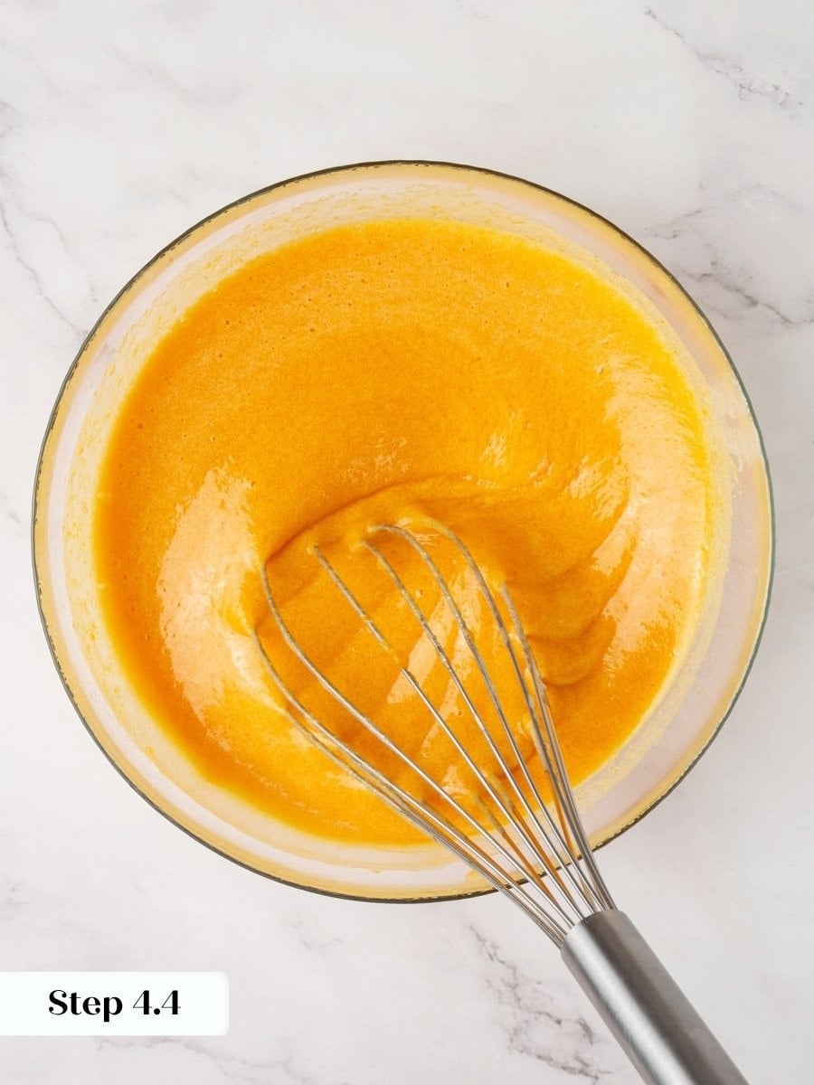 Deep orange and glossy signals the wet base for pumpkin cream cheese muffins is ready.