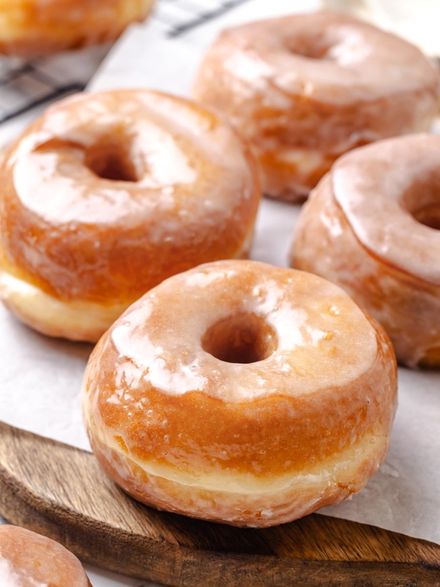 Side light catches the set glaze, revealing the golden fry crust beneath this Krispy Kreme donut.