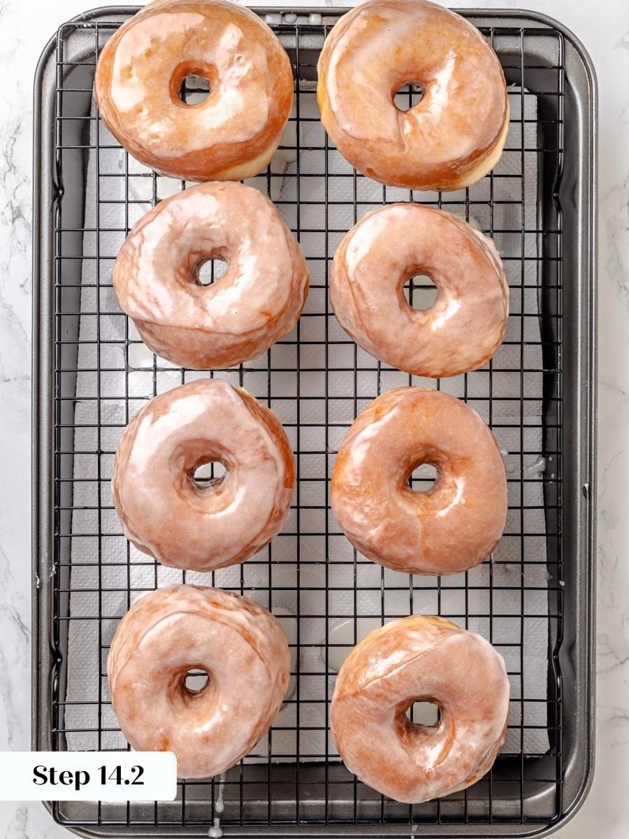 Dipping while still warm is what thins the glaze into that signature Krispy Kreme donut shell.