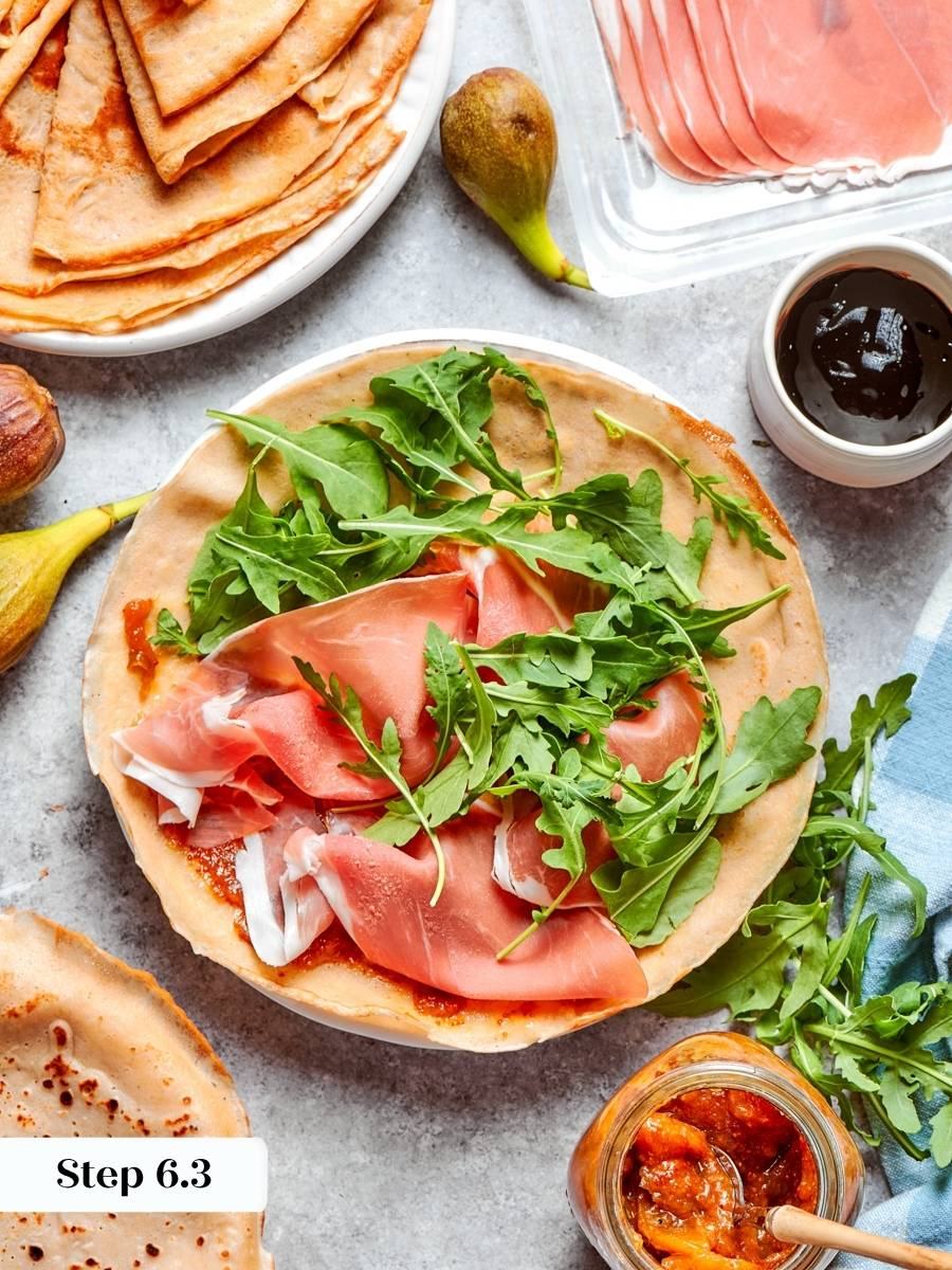 Peppery arugula cuts the jam's sweetness, the balance that makes this savory crepe recipe work.
