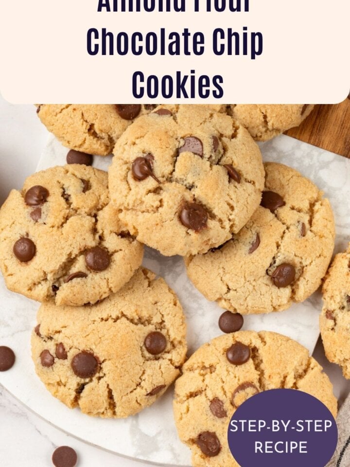 Overhead view of almond flour chocolate chip cookies arranged on a marble board with scattered chocolate chips