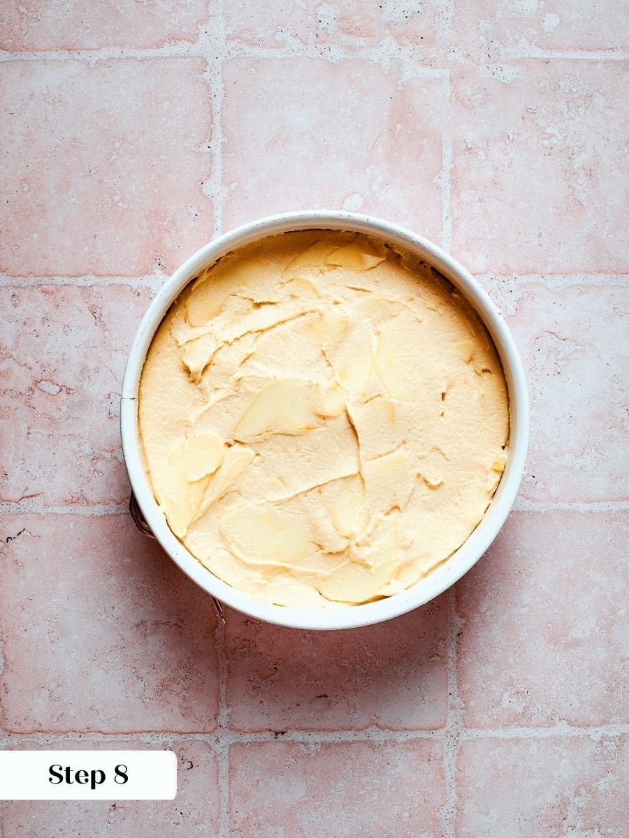 Spreading batter into the pan is the last hands-on step before french apple cake bakes.