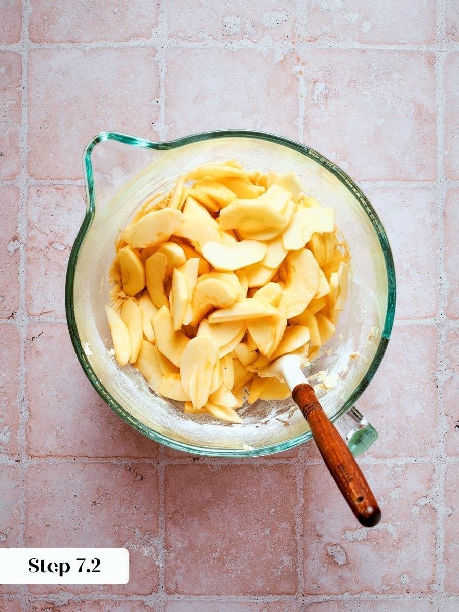 Folding apple slices into almond cream batter is the final mix step for french apple cake.