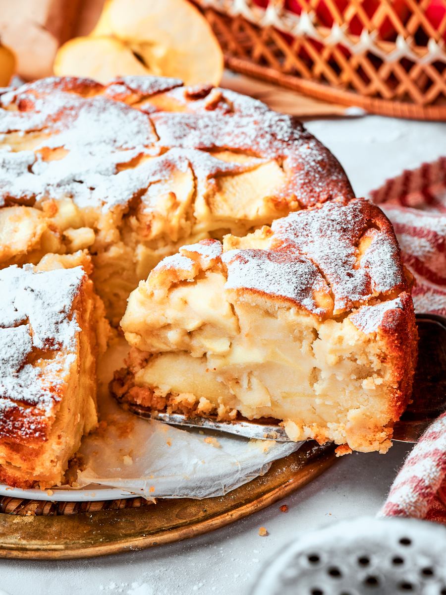 Golden top and moist crumb visible together make this slice of french apple cake look irresistible.
