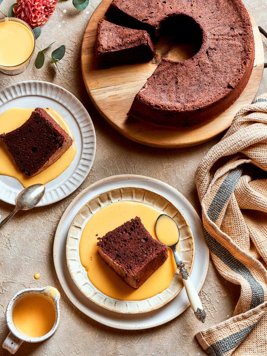 Tall slices of chocolate angel food cake are ready to share with vanilla sauce.