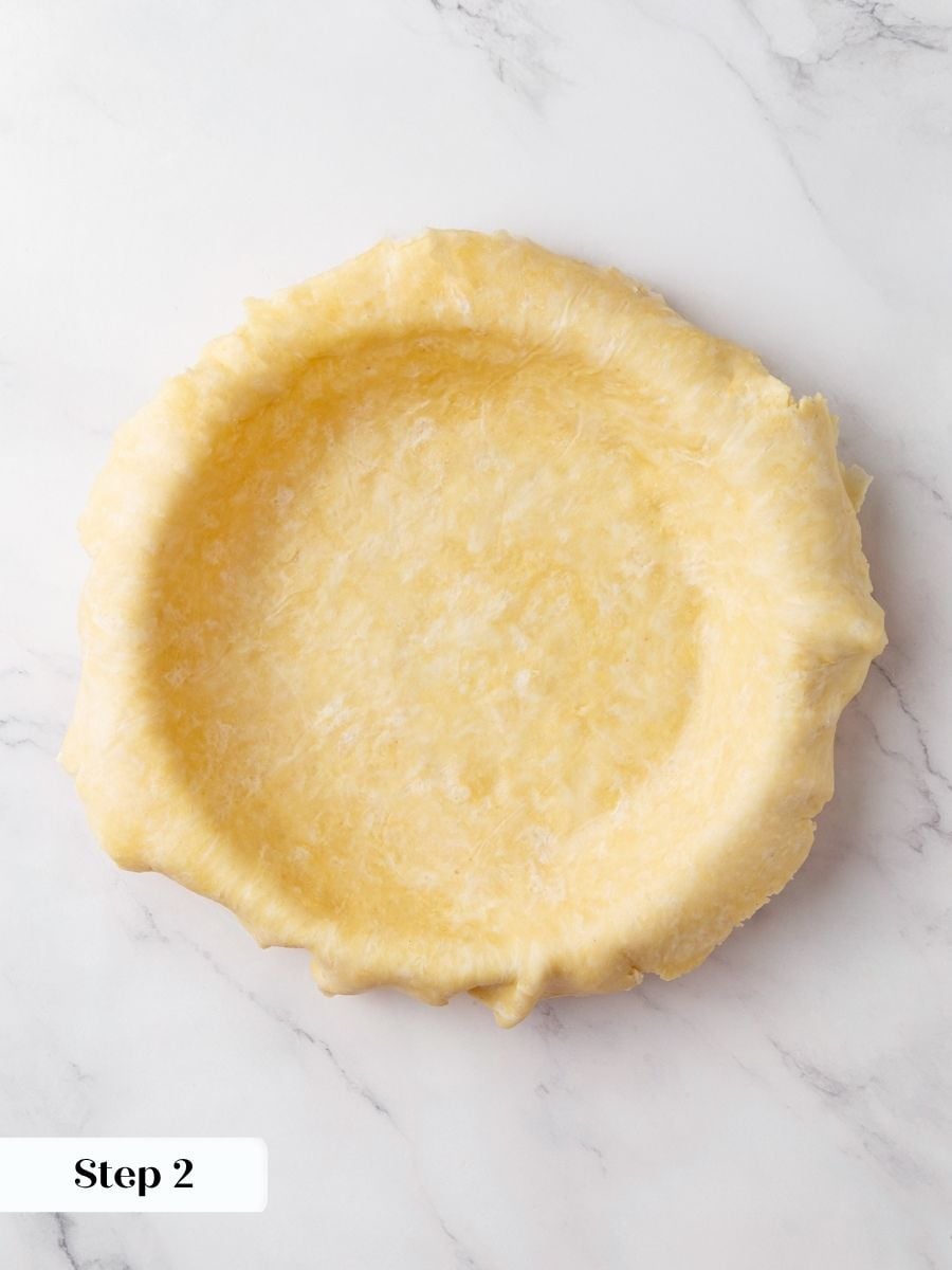 Easing the dough in without stretching stops the chocolate fudge pie crust from shrinking.